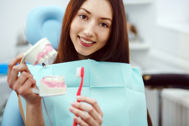 Paciente feliz con un cepillo de dientes y un molde dental