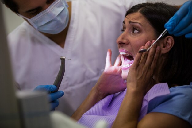 Paciente femenino asustado durante un chequeo dental