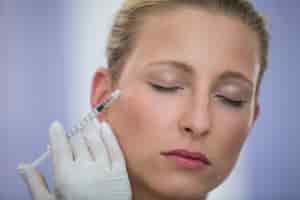 Foto gratuita paciente femenino que recibe una inyección de botox en la cara