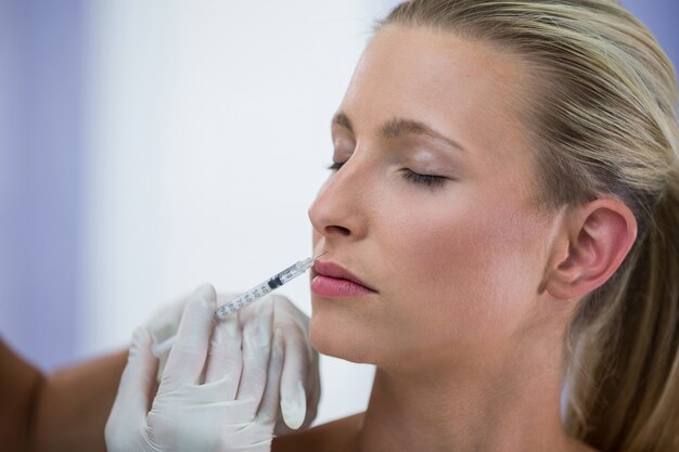Paciente femenino que recibe una inyección de botox en la cara