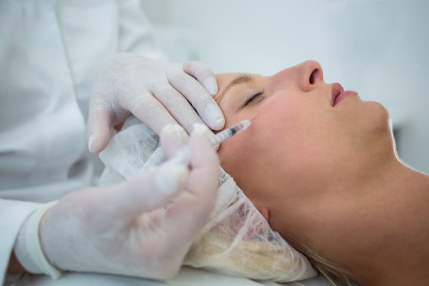 Paciente femenino que recibe una inyección de botox en la cara
