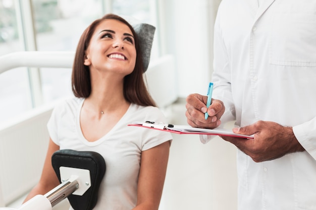 Foto gratuita paciente femenino sonriente que mira al doctor