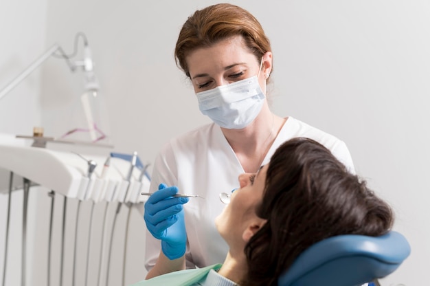 Foto gratuita paciente joven con procedimiento dental en el ortodoncista