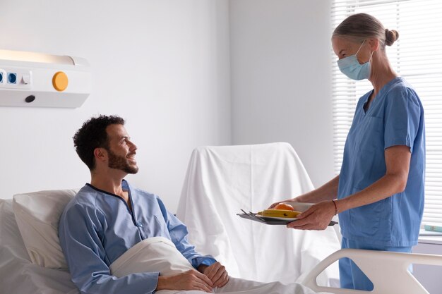 Paciente masculino en la cama hablando con una enfermera