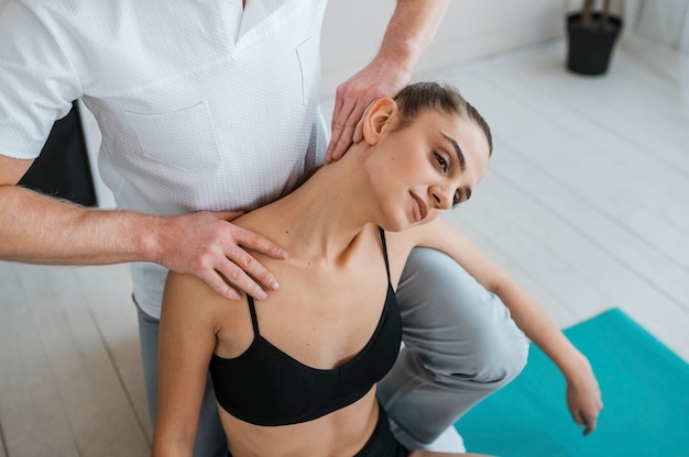 Paciente de sexo femenino en fisioterapia haciendo ejercicios con fisioterapeuta