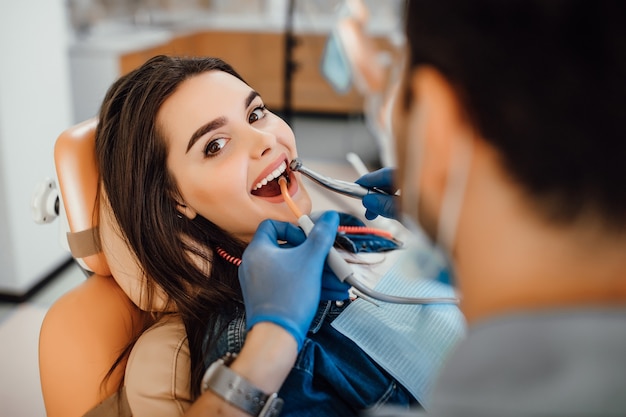 Paciente de sexo femenino joven que visita el consultorio del dentista.