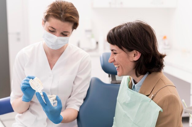 Paciente de sexo femenino que mira el molde dental con ortodoncista