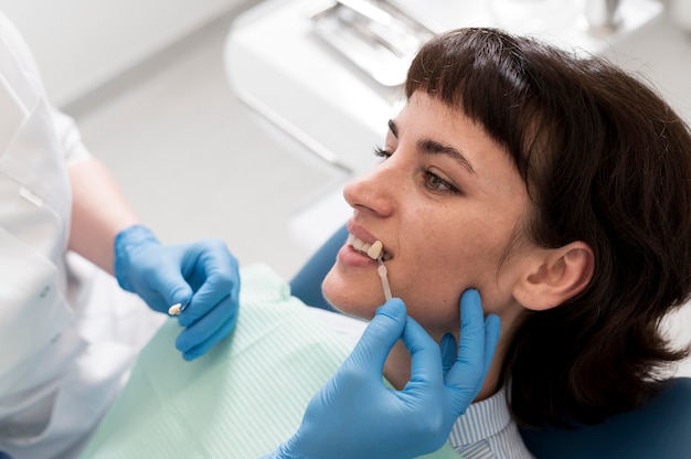 Foto gratuita paciente de sexo femenino que tiene un procedimiento realizado en el dentista