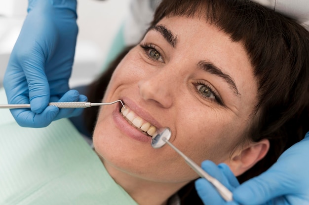 Foto gratuita paciente de sexo femenino que tiene un procedimiento realizado en el dentista