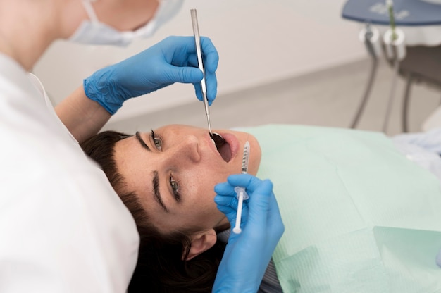 Paciente de sexo femenino que tiene un procedimiento realizado en el dentista