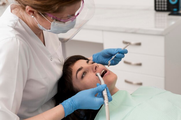 Paciente de sexo femenino que tiene un procedimiento realizado en el dentista