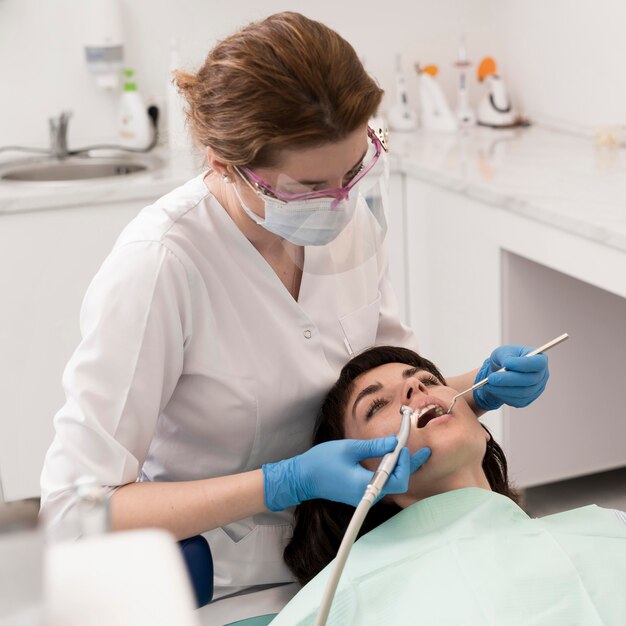 Paciente de sexo femenino que tiene un procedimiento realizado en el dentista