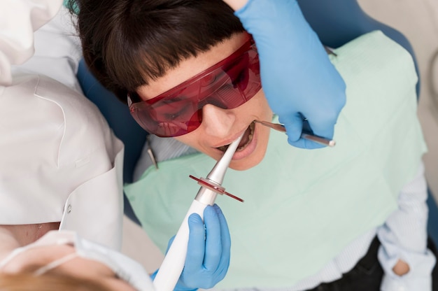 Foto gratuita paciente de sexo femenino que tiene un procedimiento realizado en el dentista