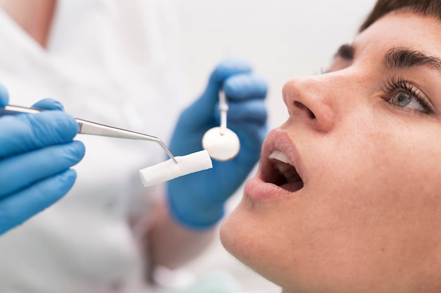 Foto gratuita paciente de sexo femenino que tiene un procedimiento realizado en el dentista