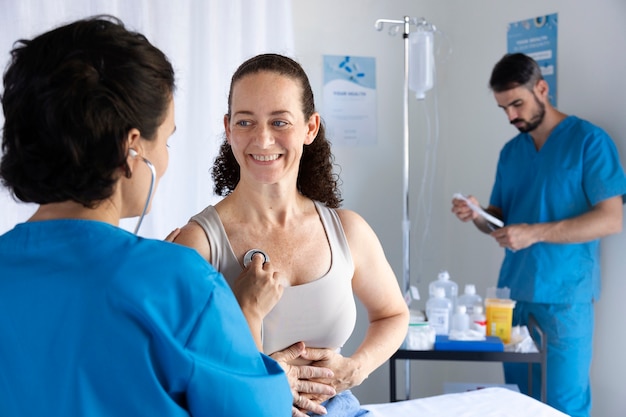 Foto gratuita paciente sonriente de tiro medio en el hospital