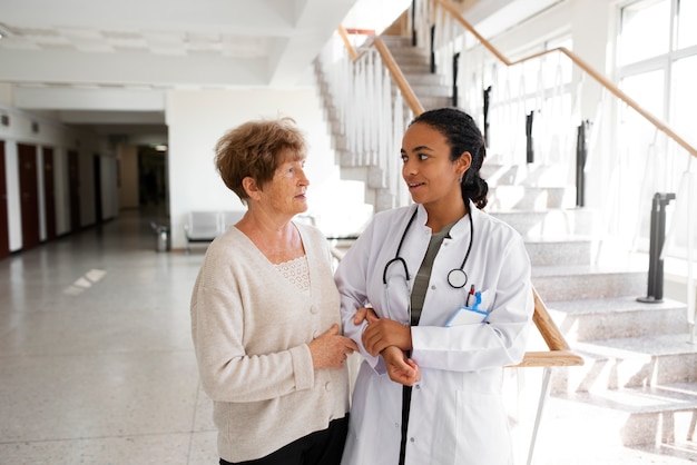 Foto gratuita paciente de tiro medio y médico en la clínica.