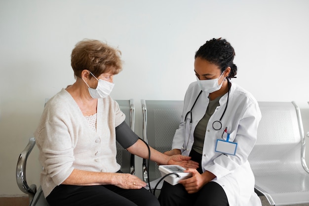 Foto gratuita paciente de tiro medio y médico con máscaras.