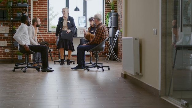 Pacientes que ingresan al consultorio para asistir a una reunión de terapia para rehabilitación con un terapeuta. Personas con adicción hablando sobre alcoholismo y recuperación con psiquiatra en círculo. programa de rehabilitación