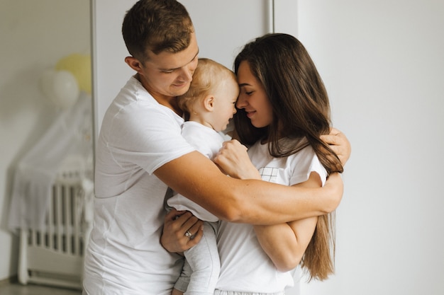 El padre abraza firmemente a su esposa y un niño pequeño.