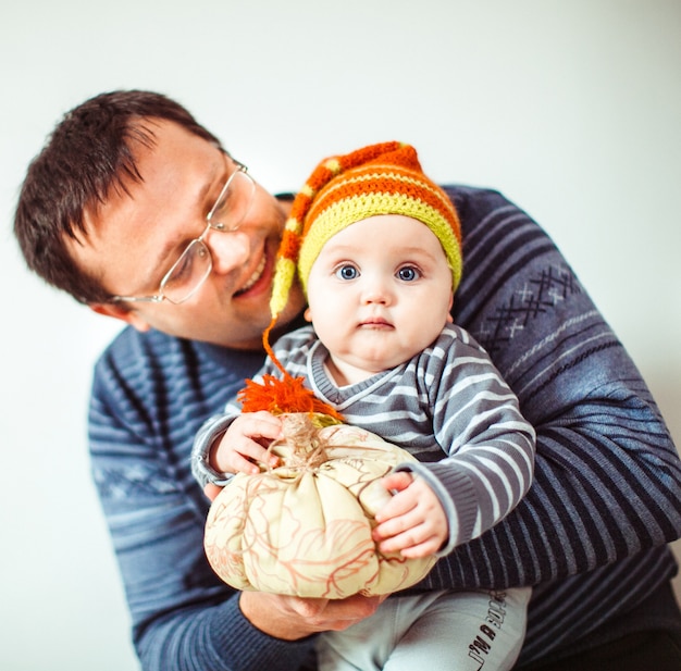 Foto gratuita padre abraza a su pequeño hijo gracioso en sombrero despojado