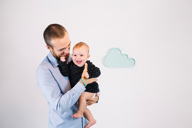 Foto gratuita padre alegre, tenencia, reír, bebé