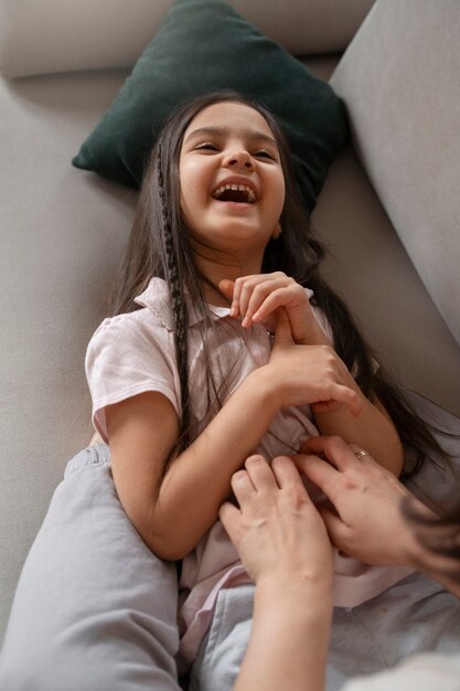 Padre de alto ángulo haciendo cosquillas al niño en el sofá