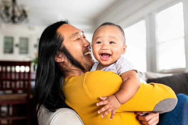 Padre asiático americano abrazando a su pequeño hijo