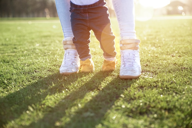 Padre ayudando a un niño a caminar en el parque