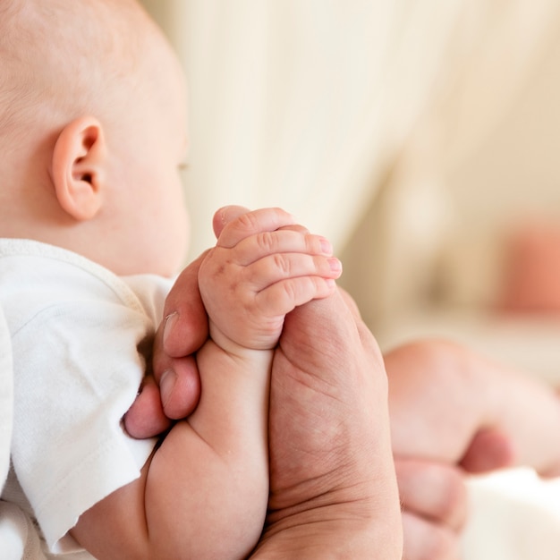 Padre y bebé cogidos de la mano