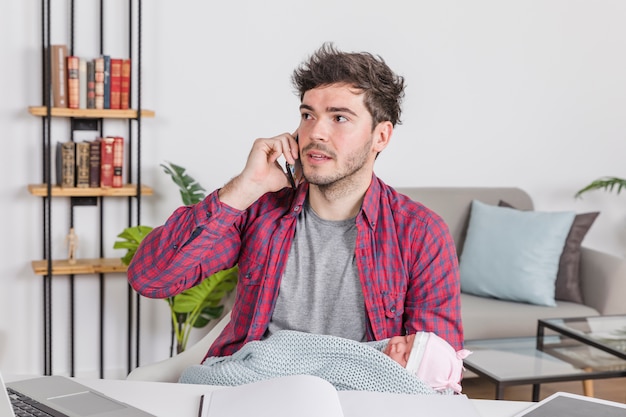 Padre con bebé hablando por teléfono