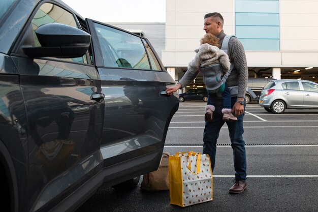 Padre con bebé en portabebés tiro completo