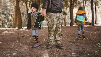 Foto gratuita padre de la cosecha con niños en el bosque