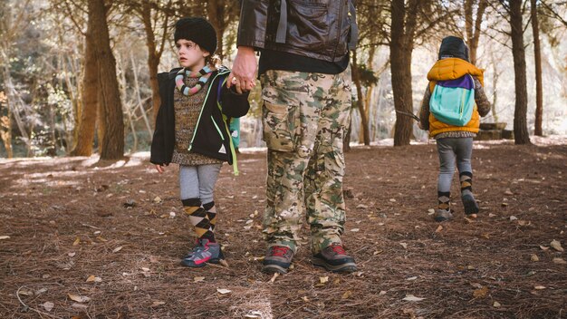 Padre de la cosecha con niños en el bosque