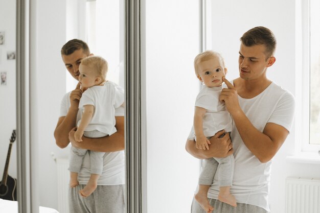 Padre disfruta de las mejillas de su pequeño hijo.