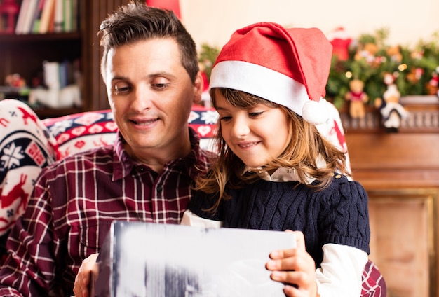 Padre e hija abriendo un regalo de navidad