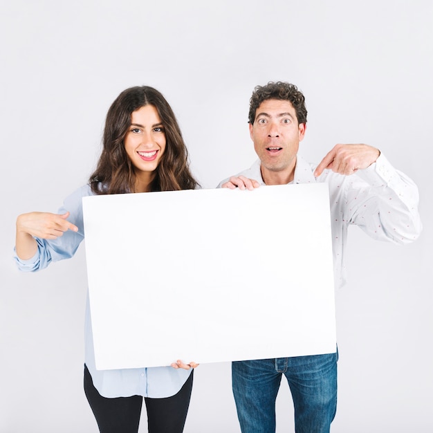 Foto gratuita padre e hija apuntando a la pancarta en blanco