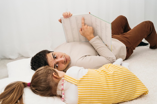 Foto gratuita padre e hija en la cama en casa pasar tiempo juntos