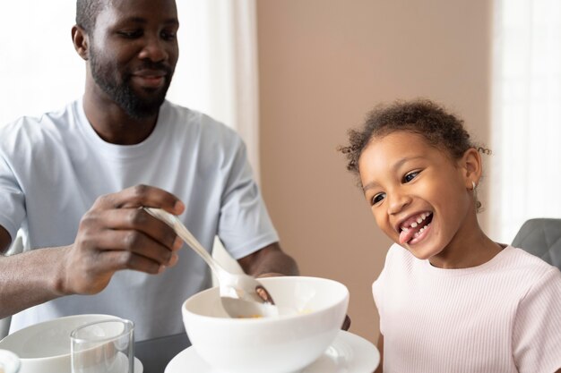 Padre e hija comiendo en la cocina