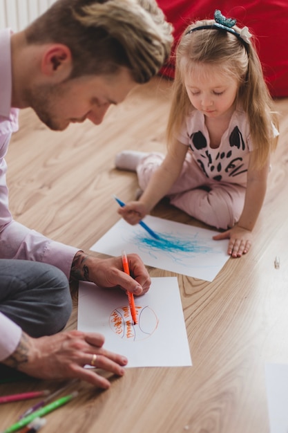 Padre e hija concentrados dibujando