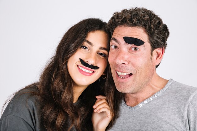 Padre e hija se divierten con bigotes falsos