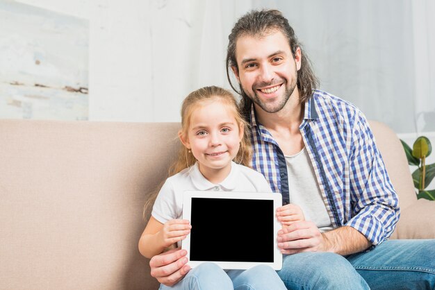 Padre e hija enseñando la tablet