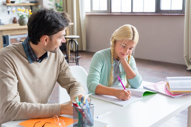 Padre e hija haciendo la tarea en el interior