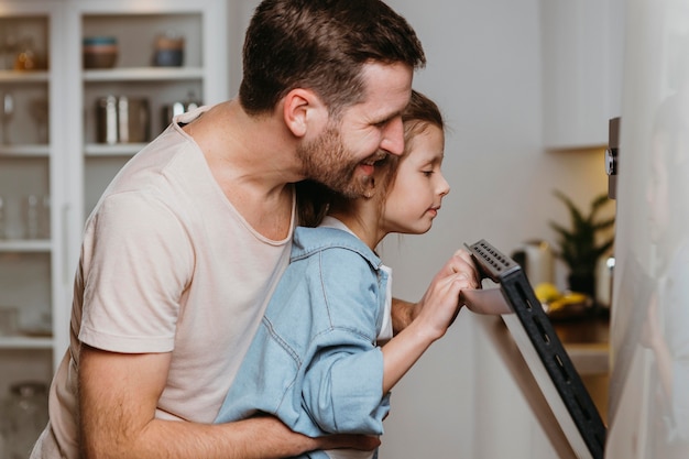 Foto gratuita padre e hija horneando galletas juntos