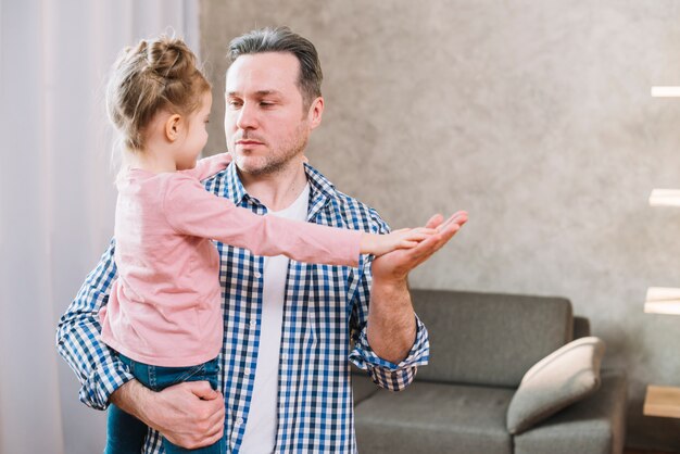 Padre e hija jugando a aplaudir mientras se miran