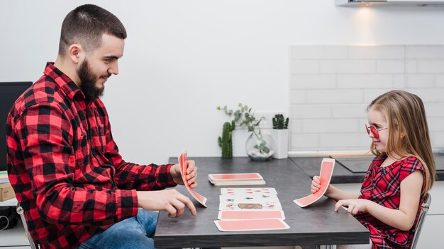 Padre e hija jugando a las cartas en el día del padre