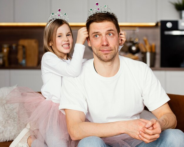 Padre e hija jugando con tiara juntos