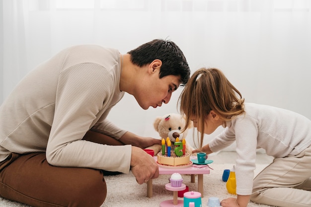 Padre e hija con juguetes en casa
