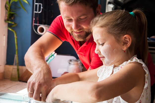 Padre e hija con las manos en un recipiente