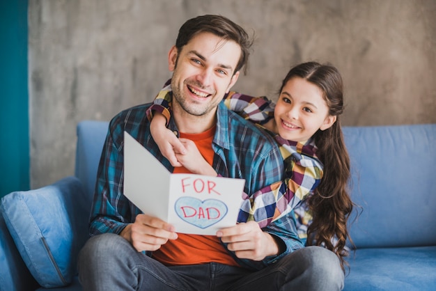 Foto gratuita padre e hija mirando a tarjeta en el día del padre