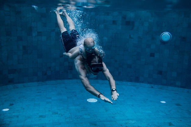 Padre e hija nadando juntos en la piscina